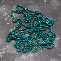 Long turquoise beads from lie on a gray surface