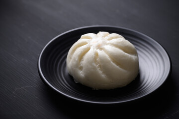 Steamed bun stuffed with minced pork on black background, Asian food