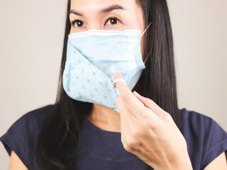 Asian woman wearing  blue  polka dot cloth mask on medical face mask  for better protection  from covid-19 outbreak.Double face masks for covid19 protection.