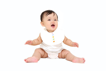 白背景でお座り笑顔で見上げる女の子の赤ちゃん。成長,健康,元気,育児イメージ