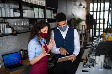 Coffee shop manager discussing issues with waitress in cafe, small business and new normal concept.