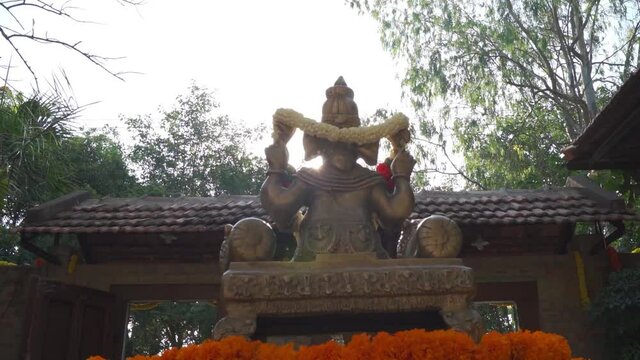 Lord Ganesha with garland in daylight. Back shot of Lord Ganesha.