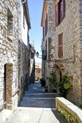 Fototapeta na wymiar A street between old medieval stone buildings of Bassiano, historic town in Lazio region, Italy.
