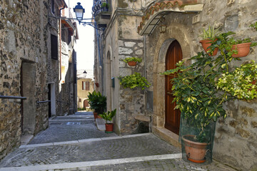 Fototapeta na wymiar A street between old medieval stone buildings of Bassiano, historic town in Lazio region, Italy.