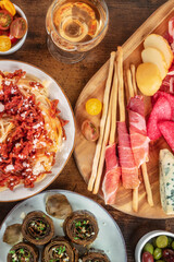 Italian antipasti and pasta. Grissini with prosciutto, artichokes, and wine