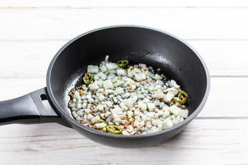 Fried onions with spices in a pan. Ingredients for cooking Gobi Aloo cauliflower and potatoes, horizontal