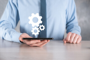 Business man in suit holding metal gears and cogwheels mechanism representing interaction teamwork concept,hand hold group of virtual cog gears wheel
