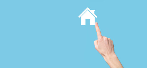 Male hand holding house icon on blue background. Property insurance and security concept.Real estate concept.