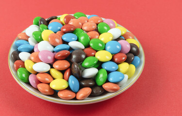 Round colored milk chocolate dragees on a plate