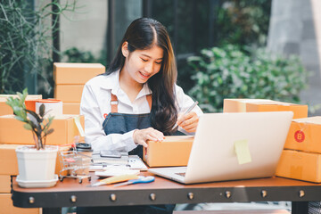 Starting Small business entrepreneur SME freelance,Portrait young woman working at home outdoor, BOX,smartphone,laptop, online, marketing, packaging, delivery, SME, e-commerce concept  