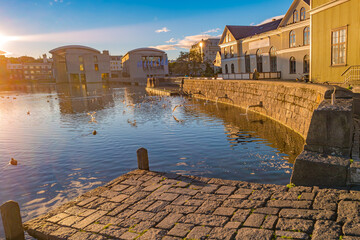 Obraz premium Historical downtown in Reykjavik at warm Summer sunset in the city lake Tjornin, Iceland.