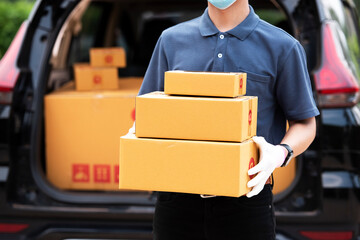 Asian man delivering parcels Carrying a cardboard box in front of the van High quality photos