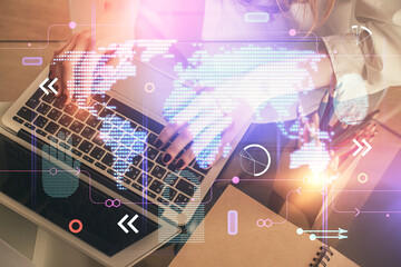 Double exposure of woman hands working on computer and world map hologram drawing. International technology business concept.