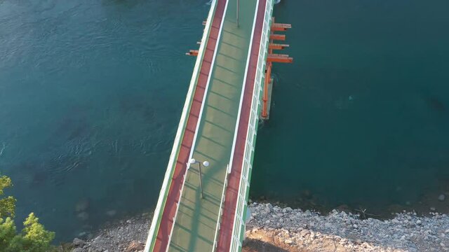 Footbridge: bridge for pedestrians and cyclists - overpass walkway with bike lanes. Steel bridge over canal as separation structure in sustainable transport system. Falsework scaffolding support.