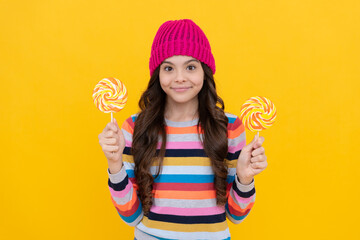 hipster kid with colorful lollypop sugar candy on stick. caramel candy shop.