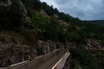 Asphalt road through the mountains forest in rainy season
