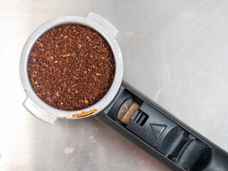 Grinded roasted coffee bean in portafilter on table