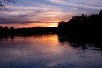 Spring sunset on the river, with blue skies, in a peaceful and quiet evening