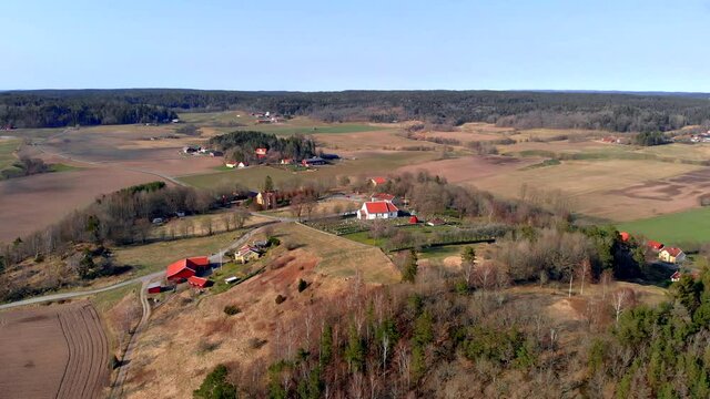 Aerial Shot Of Traditional Rural Church In Sweden Surrounded By Agricultural Farm Land Landscape