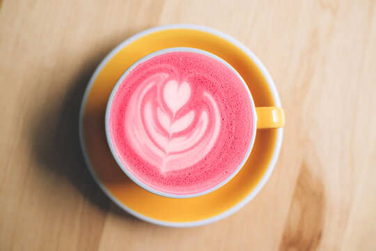 Cup of trendy beetroot latte on table.