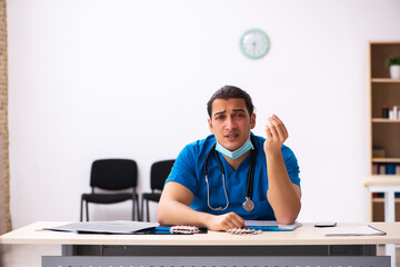 Young male doctor committing suicide at workplace