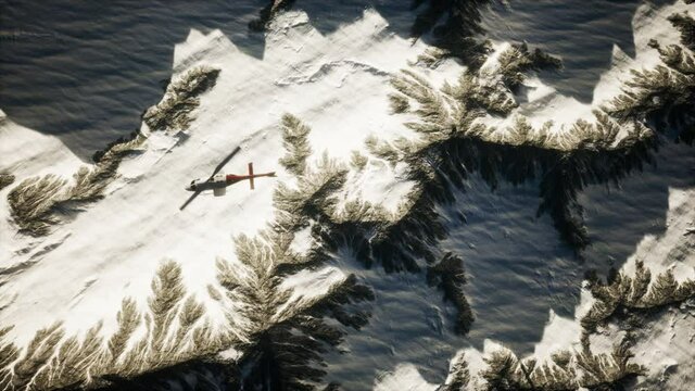 helicopter above mountains in snow
