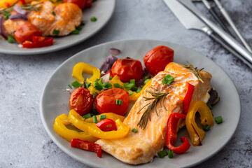 Baked red fish fillet Arctic char on a plates with vegetables close up, delicious hearty healthy...
