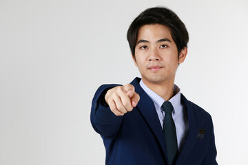 One asia man stand point finger to camera. Studio shoot half body with white background. Image good for business banner, seriously, expression concentrate.