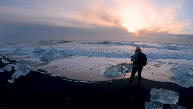 A photograph taking a photo of misty sunrise on diamond beach in iceland