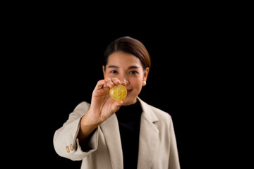 Successful Asian businesswoman standing over black background holding bitcoin money.