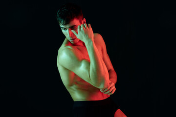 sexy athletes with pumped up arm muscles posing on a black background and bright falling light