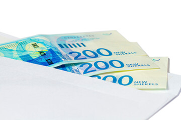Obraz na płótnie Canvas Three banknotes of 200 new Israeli shekels in a mail envelope on a white isolated background.