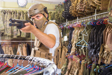 czech adult guy in military equipment with weapon in army shop