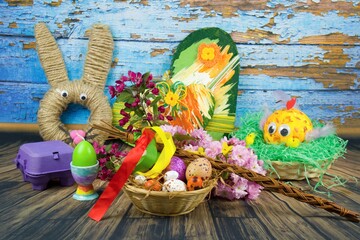 Color eggs decorated with wax and glitter and Easter decoration  in a basket and branches of...
