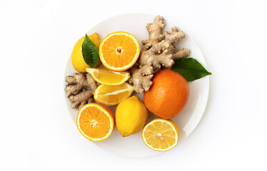 citruses on a white plate, oranges, lemons and ginger on a white plate on a white background.
