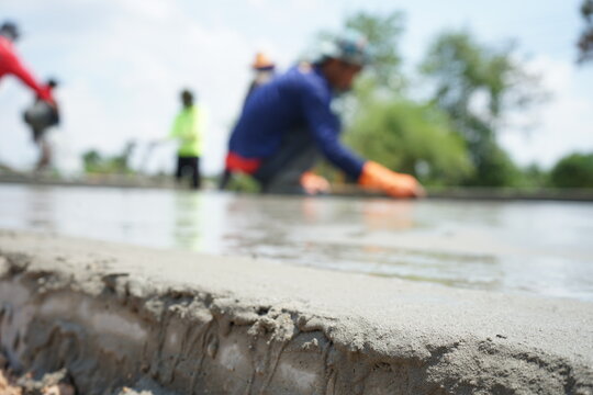 Blurred Image Of Concrete Pouring By Manual Labor