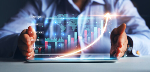 Businesswoman holding tablet with  growing virtual hologram of statistics, graph and chart.
...