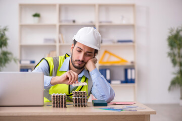 Young male architect suffering at workplace