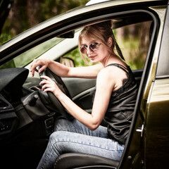 Portrait of a young smiling woman while sitting in her car