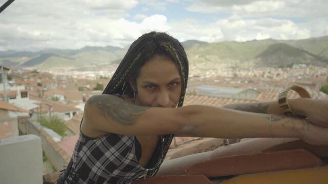 Mujer joven transgénero posando frente a la vista de la ciudad de Cusco