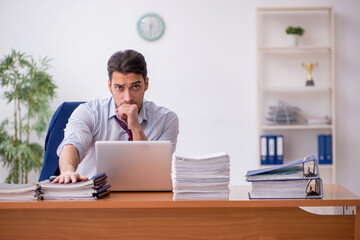Young businessman and too much work in the office
