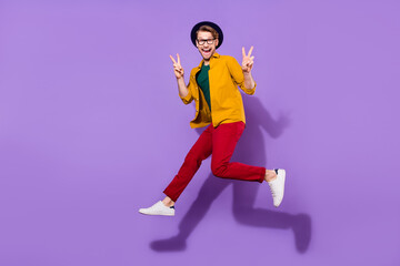 Fototapeta na wymiar Full length body size view of nice funky guy jumping showing double v-sign isolated over bright violet purple color background
