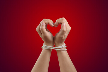 Hands in the shape of a heart tied with rope. Concept of the love of bdsm or codependency