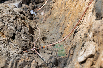 Several copper wires are connected to conductors to the ground rod of the electrical system.