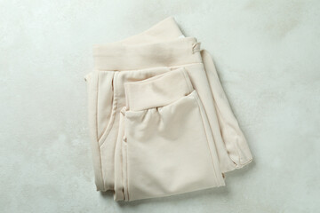 Fototapeta premium Folded sweatpants on white textured background, top view