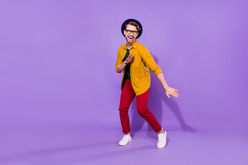 Fototapeta na wymiar Full length photo of young guy happy positive smile funny clubber dancer isolated over purple color background