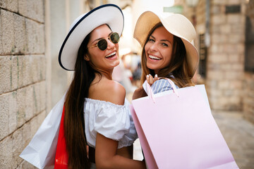 Happy friends women shopping in the city on vacation