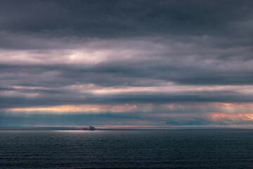 Obraz premium Ship at sea at sunset