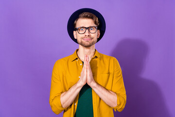 Photo of hopeful young charming man hold hands ask beg please wear glasses isolated on violet color...