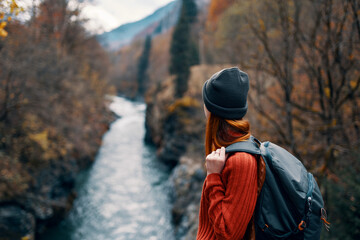 Fototapeta na wymiar woman with backpack admires the river in the mountains nature travel